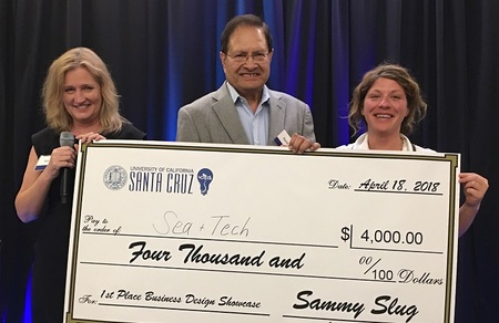 CIED director Sue Carter (left) and Kamil Hasan present the 1st place prize in the the 2018 Business Design Showcase